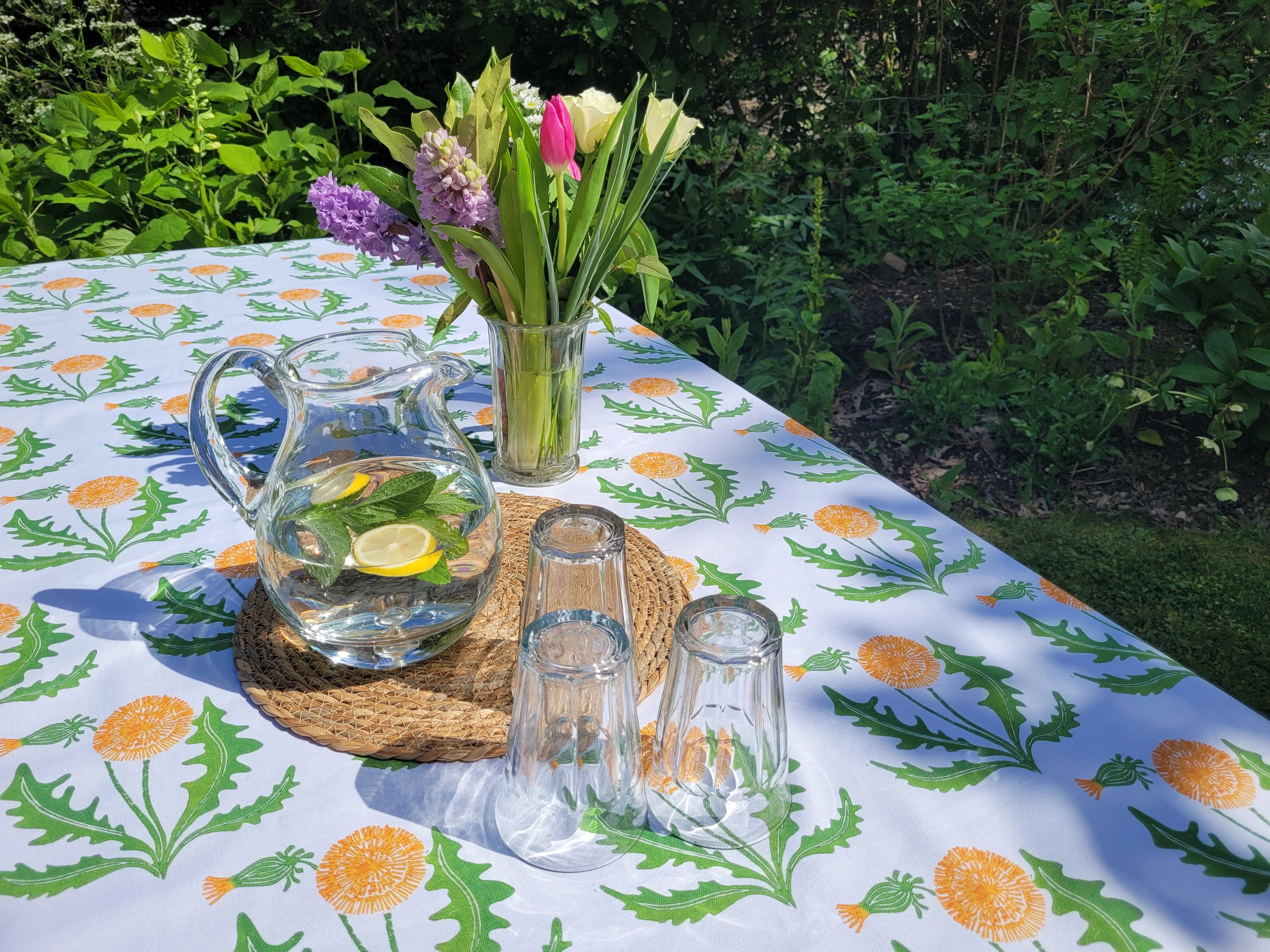 dandelion lino block printed fabric designed by lizzie mabley set on an outdoor table