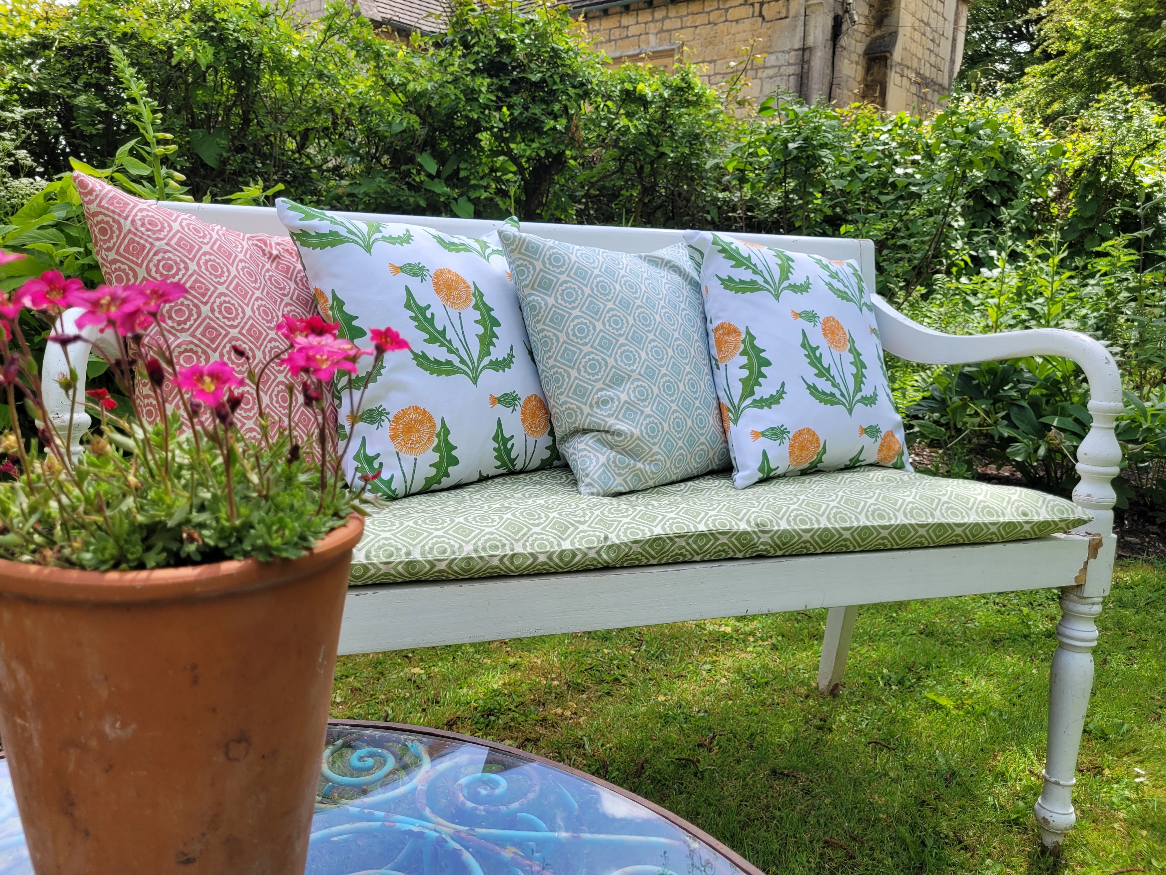 rebecca and dandelion lino block printed fabrics designed by lizzie mabley and set on a garden bench 