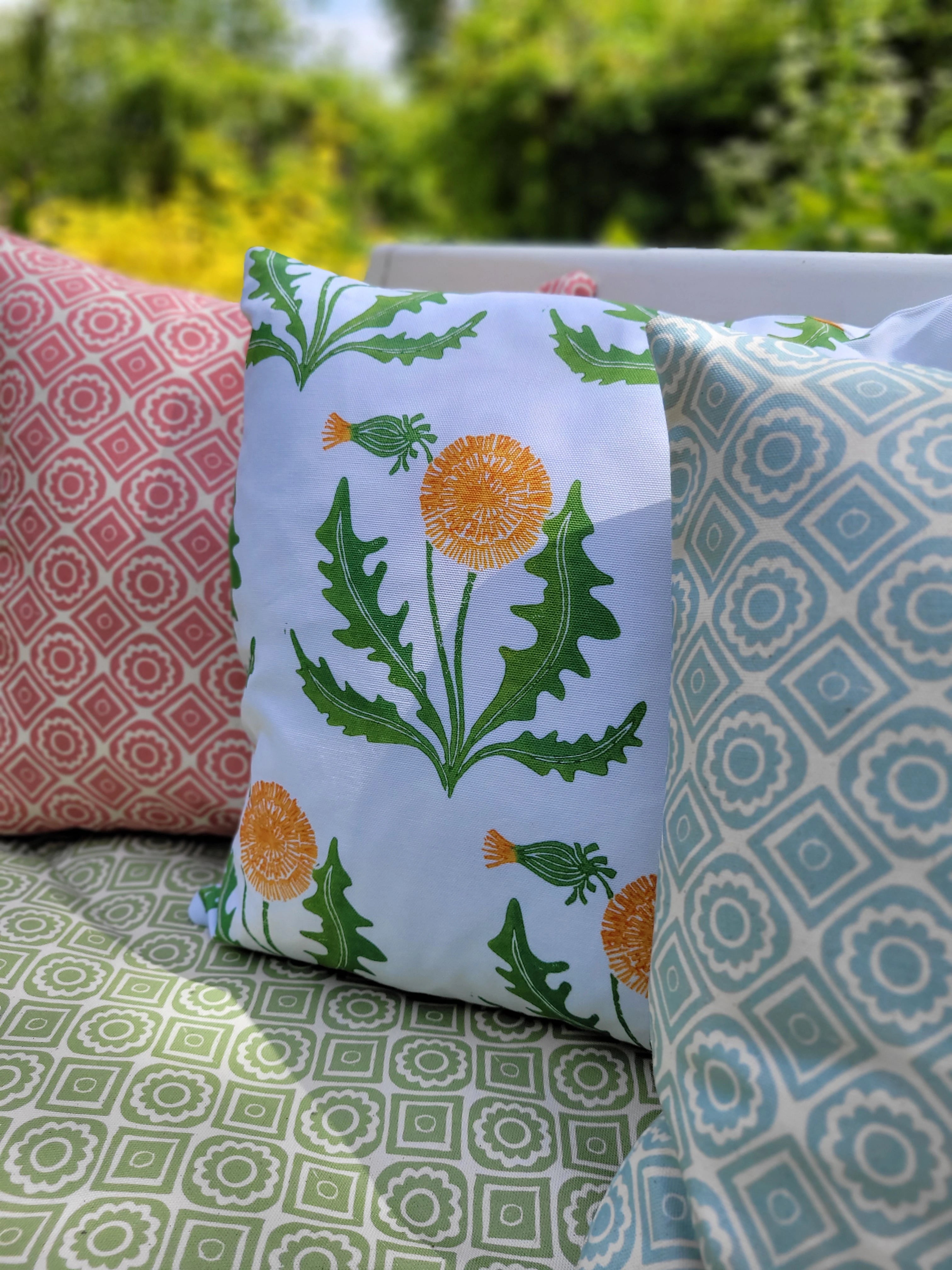 rebecca and dandelion lino block printed fabrics designed by lizzie mabley and set on a garden bench 