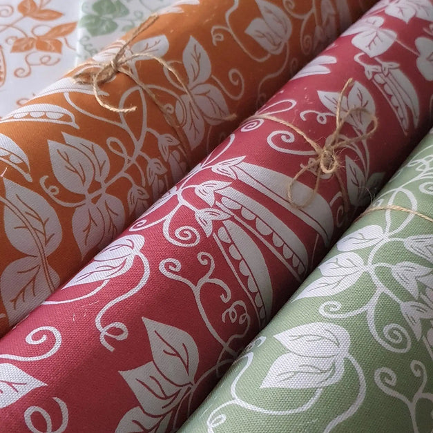Three rolls of peas fabric designed and lino cut by lizzie mabley.