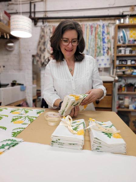 lizzie mabley in her studio inspecting dandelion napkins