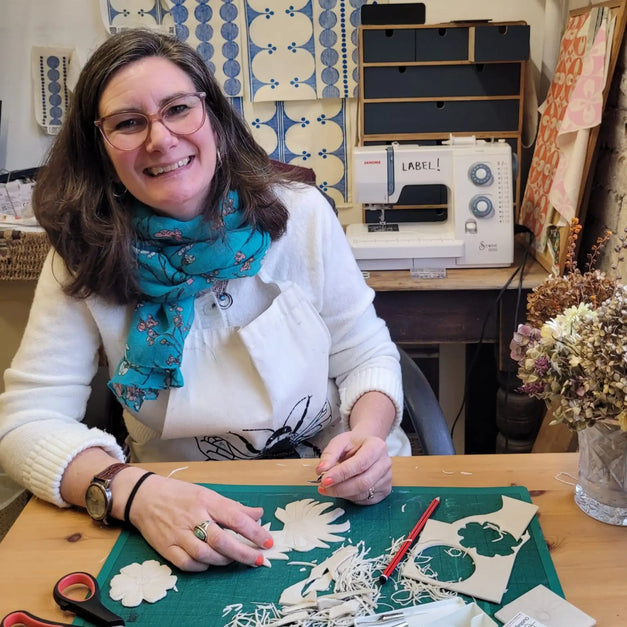 lizzie mabley carving lino blocks for printing in her studio 