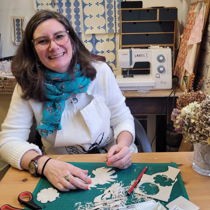 lizzie mabley carving lino blocks for printing in her studio 