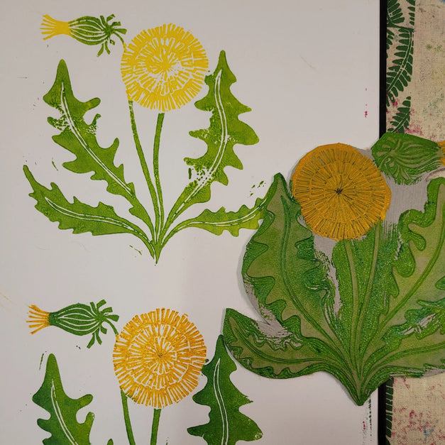 inking lino blocks for printing dandelion design by lizzie mabley
