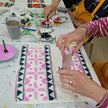 Artistic activity with patterns on a table, featuring hands and art supplies.